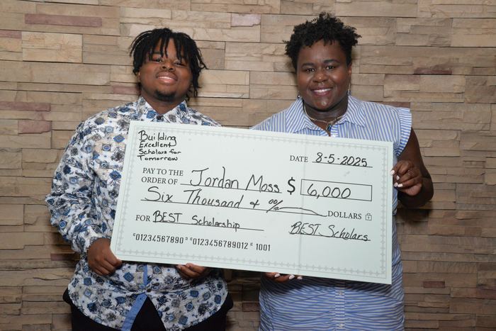 A BEST scholar with a $6,000 award check at the 2025 ceremony